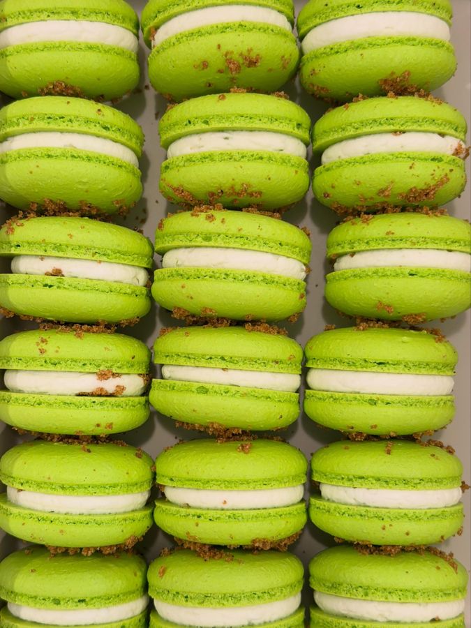 Pale green key lime macarons beside cut limes