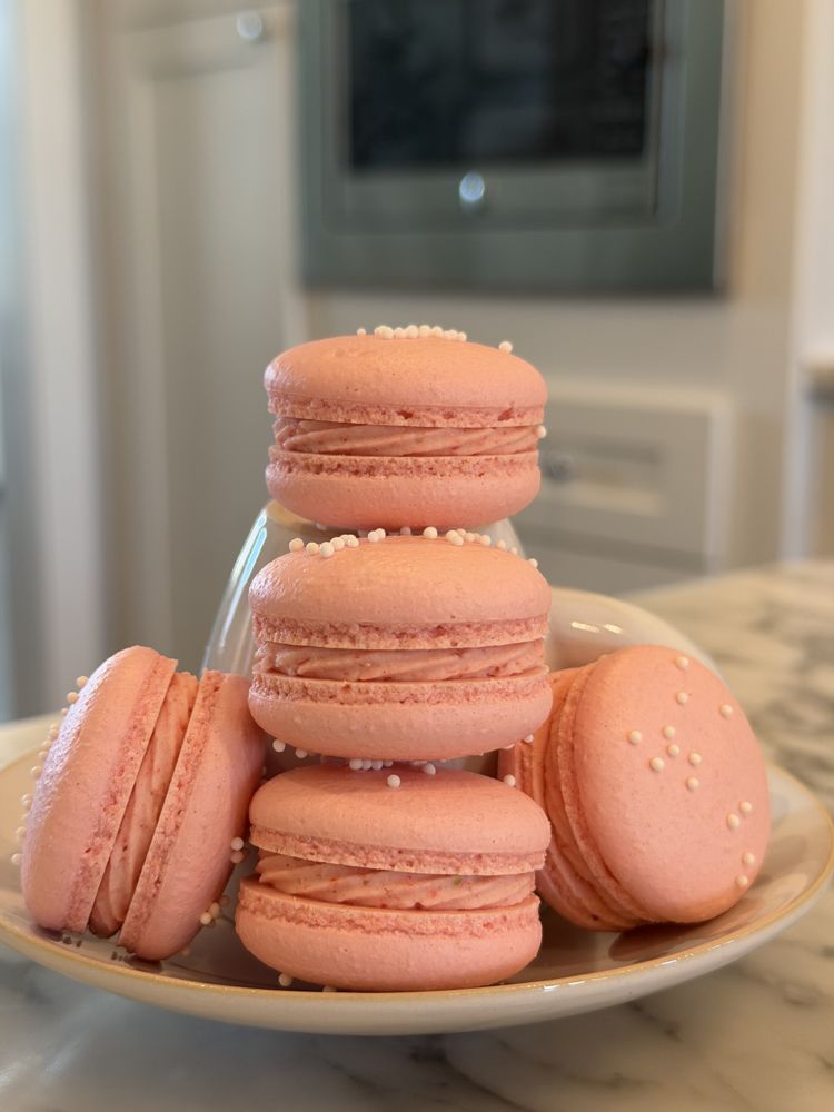 A yellow macaron on a cooling rack, seen from the side, with a neat base under the shell